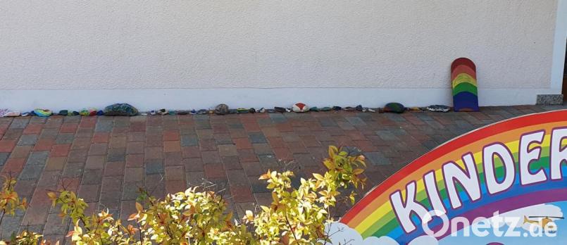 Bei der Eingangstür zum Kindergarten beginnt die Schlange aus bunt bemalten Steinen. Bild: hl