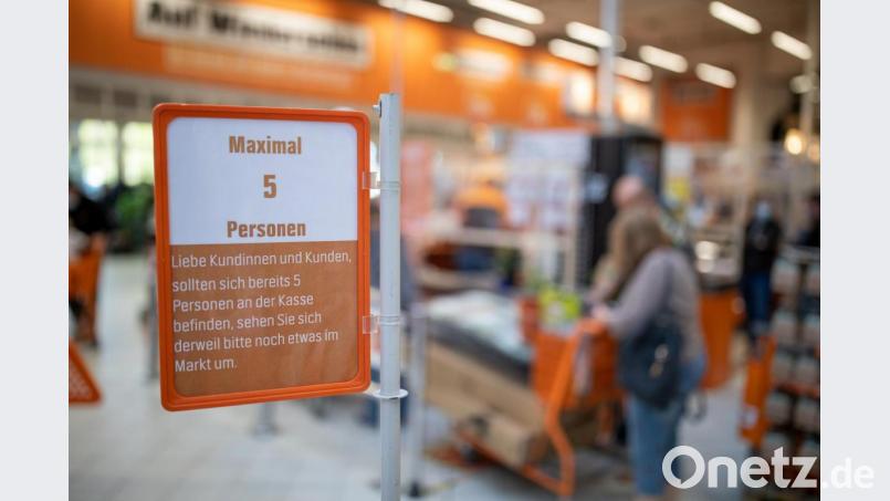&quot;Maximal 5 Personen&quot; steht auf einem Schild in einem Baumarkt wegen des Coronavirus im Kassenbereich. Vom 20. April an durften erstmals seit der angeordneten Schließung in der Corona-Krise gewisse Läden wieder öffnen. Bild: Daniel Karmann/dpa