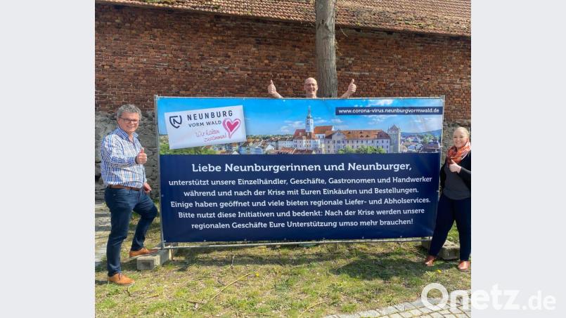Bürgermeister Martin Birner und Ulrike Meixner vom Stadtmarketing Neunburg wollen die regionalen Geschäfte mit einer Plakataktion unterstützen. Frank Langer (hinten) half kurzerhand bei der Montage. Bild: exb/Elke Reinhardt
