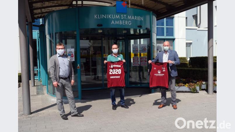 50 Ehrentrikots gab es jetzt vom 1. FC Nürnberg; v.l. Klinikumsvorstand Manfred Wendl, Reinhard Birner, Personalratsvorsitzender; Sebastian Seifert, Leiter Vertriebsmarketing 1. FC Nürnberg Bild:  Klinikum/Dietl/exb