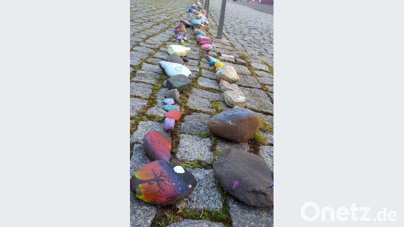 Bemalte Steine als Zeichen gegen Einsamkeit. Derzeit legen sie Kinder und auch Erwachsene am Kirchplatz vor der Stadtpfarrkirche Sankt Georg ab. Wichtig ist, dass die bunten Steine dort liegen bleiben und so die Schlange immer länger wird, ganz nach dem Motto „Lasst uns einfach etwas Freude schenken“. Bild: mng