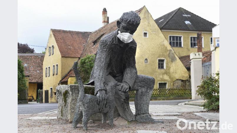Seit 2004 streichelt der Mann seine Katze in Haselmühl. Seit einiger Zeit auch mit einem Mundschutz wie er in der Coronapandemie vorgeschrieben ist. Bild: Petra Hartl