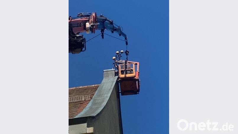 Dachdecker bauen das beschädigte Kreuz ab. Bild: le