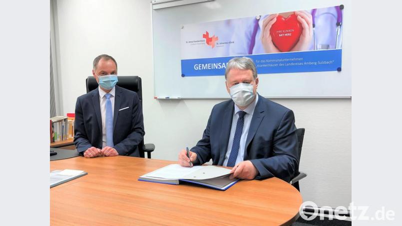 Landrat Riochard Reisinger (rechts) und Roland Ganzmann bei der Unterzeichnung des Nachfolgevertrages. Bild: St.-Anna-Krankenhaus/exb