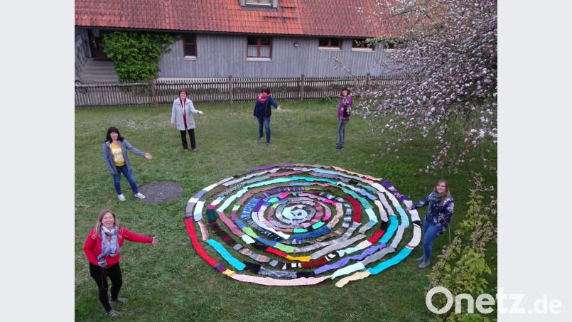 Im Garten des Pfarrzentrums präsentiert der Evangelische Frauenbund um Vorsitzende Christa Riedel (Dritte von links) seinen 100-Meter-Schal. Bild: le