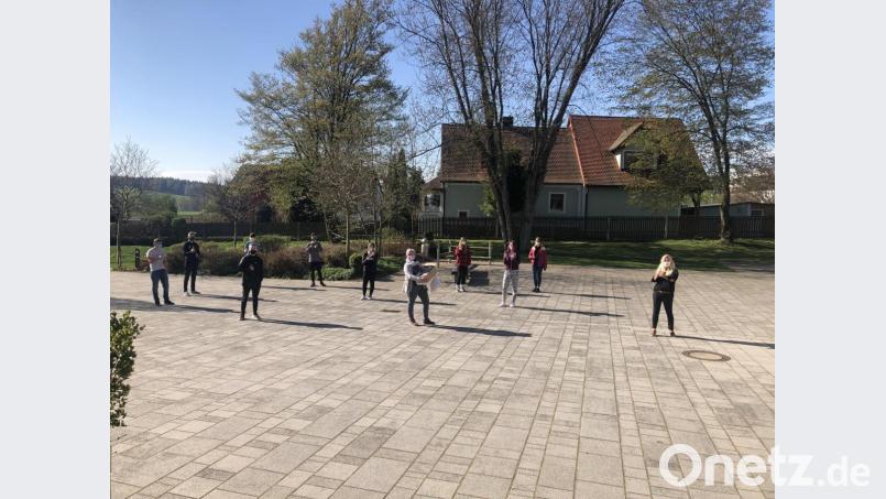 Elternbeiratsvorsitzende Silke Rosner mit einem Karton voller Masken zusammen mit Mädchen und Buben der Klasse 9 und der Schulleitung. Bild: exb