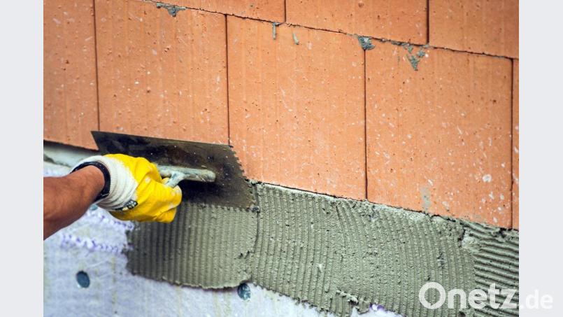 Ein Maurer trägt auf einer Baustelle Klebemörtel auf eine Wand auf. Das Handwerk in der Region baut darauf, dass die Gemeinden trotz Corona ihre Bauvorhaben verwirklichen. Bild: Lino Mirgeler