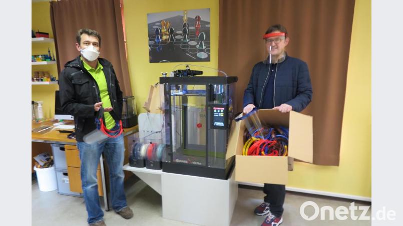 Fachoberlehrer Mathias Frischholz (rechts) übergab Versorgungsarzt Dr. Peter Deinlein 
Face-Shields und Maskenhalterungen. Bild: jzk