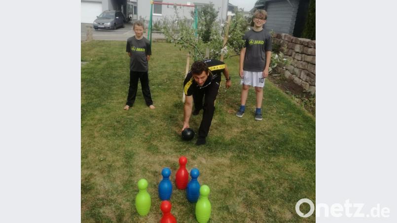 Was macht eigentlich ein Kegler in der Coronakrise? Er kegelt im Garten, zur Not auch mit Plastikkegeln. Andreas Schwaiger (Mitte) zeigt seinen Söhnen Timo (links) und Fabian, wie der technisch perfekte Wurf aussieht. Im Hintergrund besagter Apfelbaum. Bild: privat