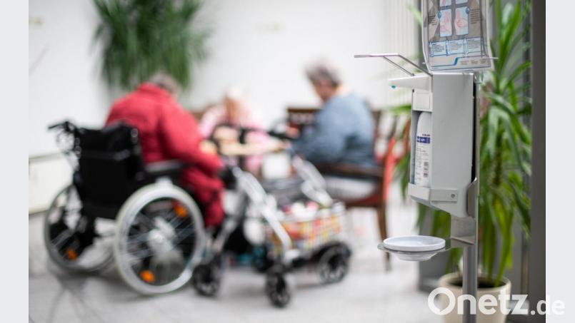 ARCHIV - 13.03.2020, Nordrhein-Westfalen, Heinsberg: Ein Desinfektionsmittelspender hängt im Johannes-Sondermann-Haus des AWO Altenzentrums während im Hintergrund Seniorinnen spielen. (zu dpa: «Ausblick auf den Besuchs-Sonntag im Altenheim an Muttertag») Foto: Jonas Güttler/dpa +++ dpa-Bildfunk +++ Bild: Jonas Güttler