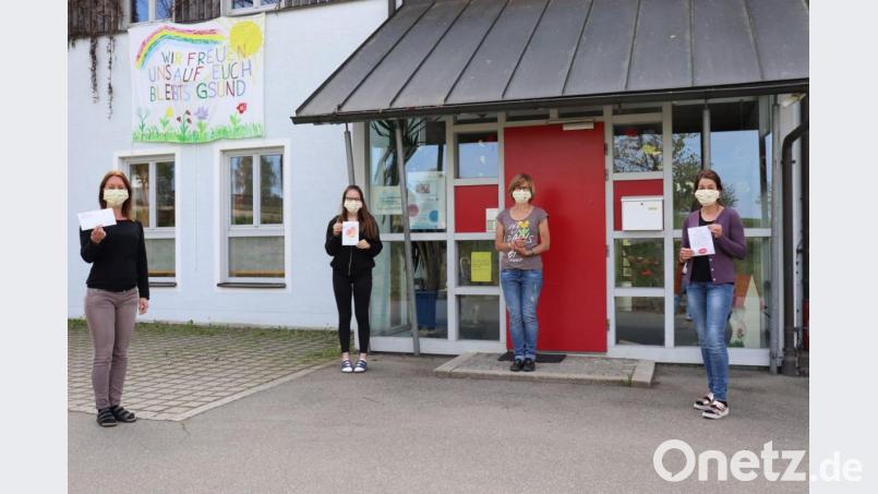 Die Kindergartenleitung vor dem neugestalteten Eingang mit Banner. Bild: agr