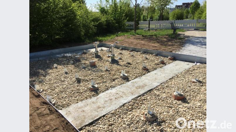 Noch nicht ganz fertig: Wo momentan metallene Pfostenträger aus einem Kiesbett ragen, entsteht eine Holzterrrasse mit markanter Dachstele. Bild: eik