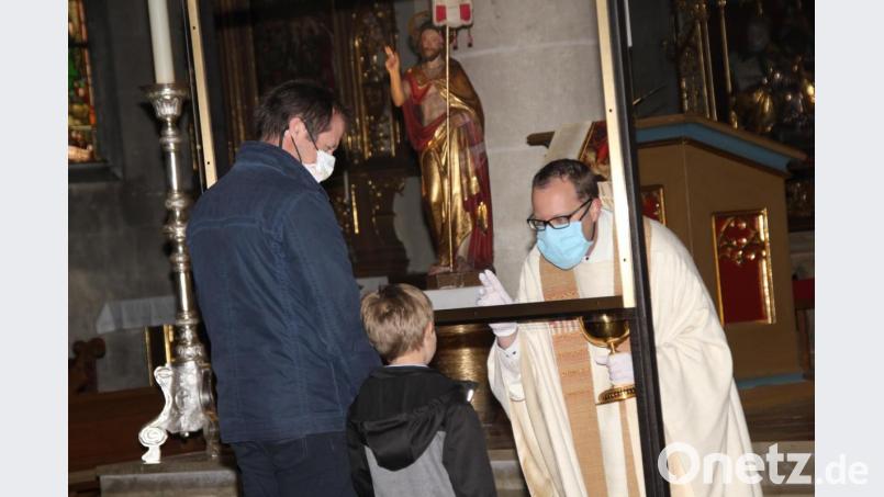 Eine fahrbare Plexiglaswand dient Pfarrer Thomas Helm beim Segnen der Kinder und beim Komunionausteilen zu seinem Schutz und zum Schutz der Gläubigen. Bild: ads