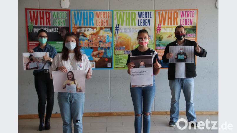„WHR hält zusammen“, gerade auch in Corona-Zeiten. Das ist die Aussage eines ermutigenden Videos der Wertebotschafterin der Schule, Elisabeth Groh (Zweite von links). Mit ihrer Klassenkameradin Hannah Bauer (Zweite von rechts) hat sie Bilder aus dem Video im Schulhaus aufgehängt, unterstützt von Martin Zimmermann (rechts), Leiter der Walter-Höllerer-Realschule und Studienrätin Isabella Sperber (links). Bild: cog