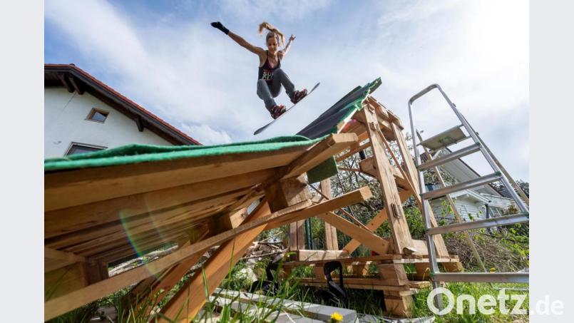 Snowboarderin Silvia Mittermüller trainiert auf ihrer selbstgebauten Mini-Schanze. Bild: Peter Kneffel/dpa