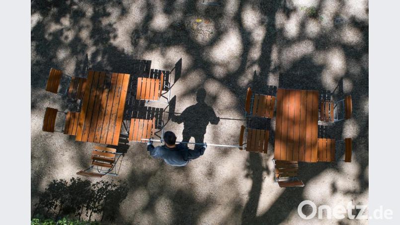 Der Mitarbeiter eines Biergartens überprüft mit einem Zollstock den richtigen Abstand der Tische. Ab dem 18. Mai darf die Gastronomie in Bayern wieder die Außenbereiche und Biergärten unter Auflagen öffnen. Bild: Thomas Frey/dpa