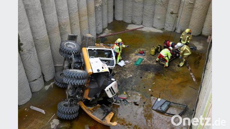 Sanitäter und Feuerwehrleute bereiten einen verletzten Baggerfahrer auf seine Bergung vor. Ein 23 Jahre alter Baggerführer aus Neumarkt ist auf einer Baustelle in der Ruhrgebietsstadt samt Bagger in eine etwa acht Meter tiefe Grube gefallen. Er wurde am Seil aus der Grube geborgen. Bild: Stephan Witte/KDF-TV &amp; Picture/dpa