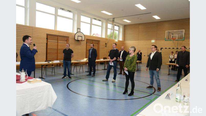 Bürgermeister Sebastian Hartl (links) vereidigt die neuen Marktgemeinderatsmitglieder Maximilian Hotek, Georg Schärtl, Christopher Mayer, Reinhard Püttner, Julia Bayer, Benedikt Lindner und Günther Weiß. Bild: bey