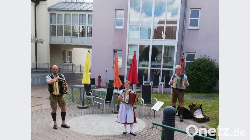 Zünftig bayerisch und beschwingt spielt auf Initiative von Hanna Ries (Mitte) das Trachtler-Musikantentrio im Innenhof des BRK-Seniorenwohn- und Pflegeheims auf und bereitet damit den Senioren eine freudige Überraschung und willkommene Abwechslung vom Corona-Alltag. Mit im Bild: Uwe Herrmann (links) und Franz Dolles (rechts). Bild: u