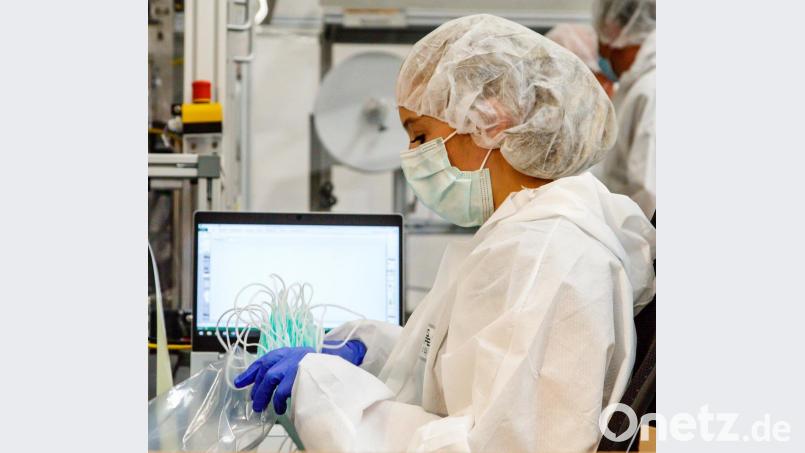 Die Mitarbeiter an der Maskenproduktion müssen komplette Schutzkleidung tragen. Je 20 Masken werden zusammen gepackt. Bild: Hösamer