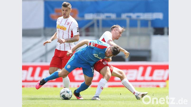 Fußball mit Zweikämpfen und Körperkontakt: Der Kieler Salih Özcan (vorne) im Infight mit Regensburgs Max Besuschkow. Bild: Alexander Hassenstein/dpa