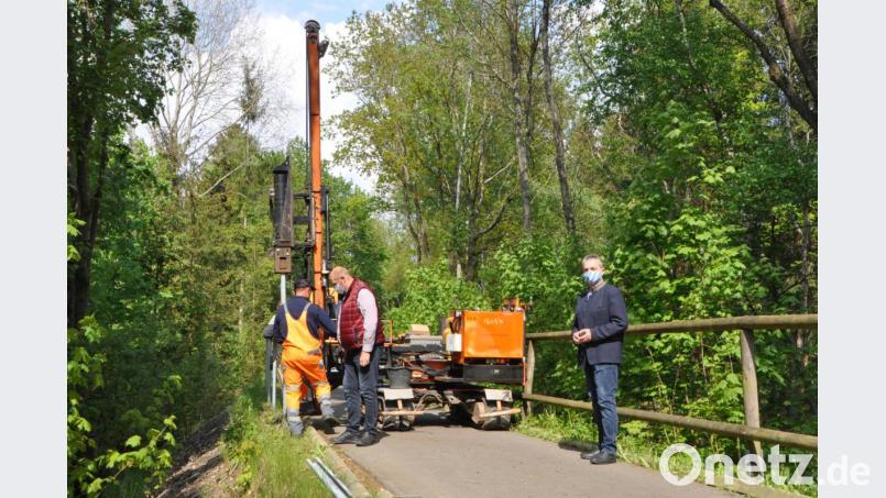 Unter lautem Getöse und Hämmern werden die Stahlpfostenhalterungen in die Erde gerammt. Bürgermeister Andreas Wutzlhofer (rechts) und Außendienstleiter Karl Frey (Mitte) überzeugen sich vom Einbau. Bild: dob