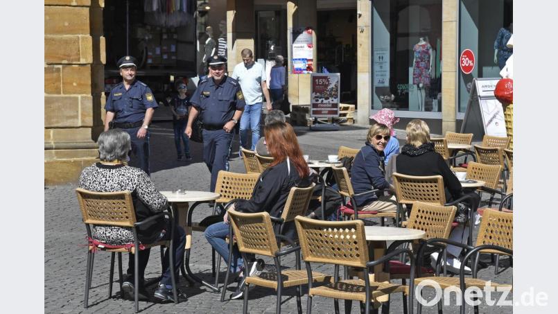 Unter dem aufmerksamen Blick einer Polizeistreife und bei bestem Frühlingswetter genießen die Gäste am Marktplatz den ersten Kaffee in den nach zweimonatiger Zwangspause wieder geöffneten Gastro-Betrieben. Pro Tisch dürfen meist nur zwei Personen Platz nehmen. Bild: Petra Hartl