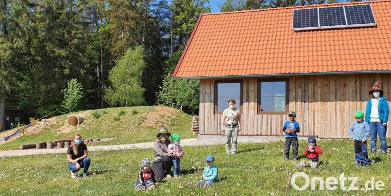 Maria Obermeier, Geschäftsführerin von OBM Baumaschinen (links), spendete 3000 Euro an den BRK-Waldkindergarten in Kainsricht für eine Solaranlage. Damit haben die Kinder, Erzieherinnen und Kinderpflegerinnen um Leiterin Sabine Lindner (Mitte, hinten) in der Hütte am Waldrand nun Strom. Derzeit werden wegen der Corona-Pandemie hier im Räuberwald nur wenige Kinder betreut. Bild: wih
