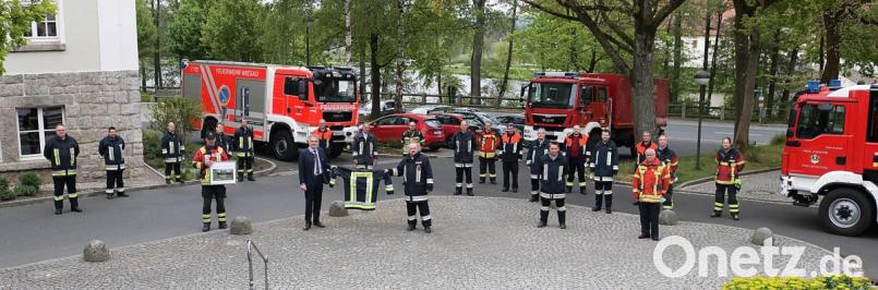 Kreisbrandrat Andreas Wührl (Mitte) überreichte die passende Einsatzjacke und sprach stellvertretend für alle Wehren des Landkreises die Glückwünsche aus. Franz Bauernfeind (links) überraschte den neuen Landrat mit einem besonderen Foto-Geschenk der Freiwilligen Feuerwehr Mitterteich. Bild: exb/Landkreis Tirschenreuth / Stefan Malzer