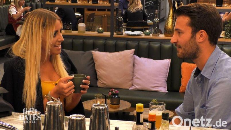 An der Bar des First-Dates-Hotels trifft Melissa zum ersten Mal auf ihr Date Christian. In der Wartezeit wärmt sie sich mit Tee und Roland Trettls Jacke. Bild:  TVNOW