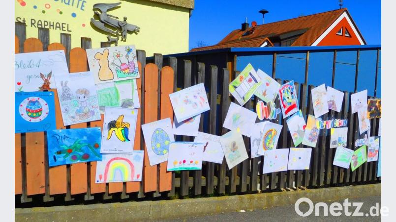 Am Außenzaun des Kindergartens St. Raphael in Kümmersbruck hängen Zeichnungen der Mädchen und Buben. Sie vermissen ihre Kita. Bild: e