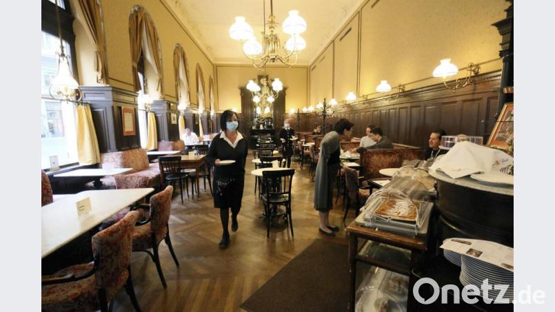 Kellnerinnen mit Mundschutzen bedienen Gäste im Café «Sperl». Nach einer 59 Tage langen Corona-Pause dürfen in Österreich alle 41 000 Gastronomiebetriebe wieder Gäste empfangen. Der Neustart am Freitag wurde im gesamten Land aber durch schlechtes Wetter getrübt. Bild: Ronald Zak/AP/dpa