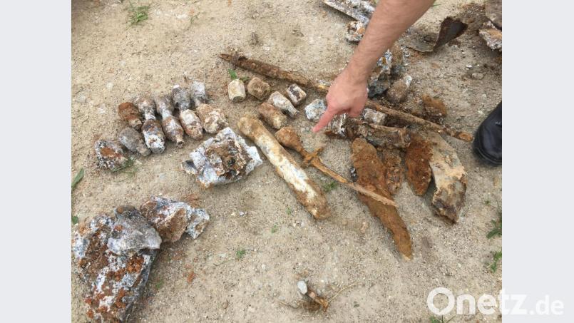 Fingerzeig auf eine ans Tageslicht beförderte Stabbrandbombe - das helle, rohrförmige Teil in der Bildmitte. Oberhalb links liegen Stahlteile, die als Gewichte dienten, neben der Bombe sieht man ein Bajonett und ganz hinten rechts den verrosteten Lauf eines Karabiners. Die befürchtete Fliegerbombe enthielt der Amberger Untergrund dann aber doch nicht. Bild: eik