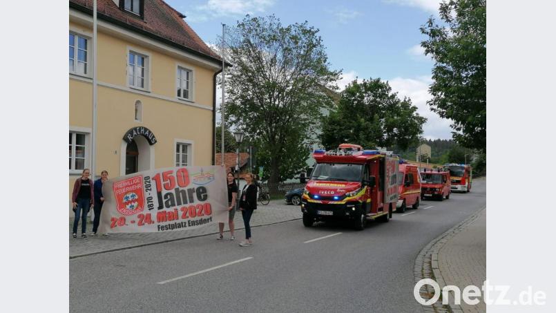 In den motorisierten Ersatz-Festzug reihten sich nicht nur zwei Fahrzeuge der Feuerwehr Ensdorf, die am Sonntag eigentlich mit einem klassischen Festzug ihr 150. Jubiläum gefeiert hätte, ein. Auch je mit einem Feuerwehrauto waren die Wehren Thanheim und Wolfsbach vertreten. Am Rathaus standen die Festdamen und jubelten dem kleinen Konvoi zu. Bild: Feuerwehr Ensdorf