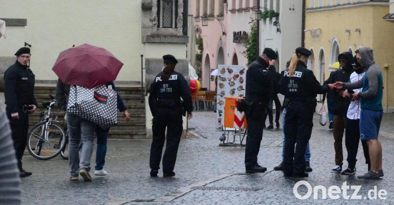 Sie tragen zwar fantasievolle Masken, halten aber den Sicherheitsabstand nicht ein. Die Polizei stellt die Personalien von vier Personen vor dem Alten Rathaus fest. Bild: Kunz