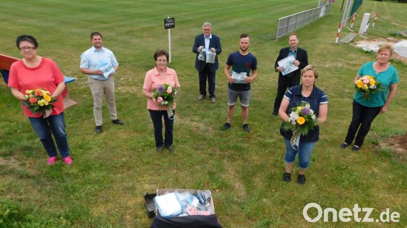 Helga Büchner, Stephan Veigl, der Blumen für die Näherinnen mitgebracht hatte, Maria Veigl, Manfred Porsch, Daniel Veigl, Bürgermeister Christian Porsch, Renate Veigl sowie Silvia Kühnel (von links) bei der Übergabe der Schutzmasken. Bild: hai