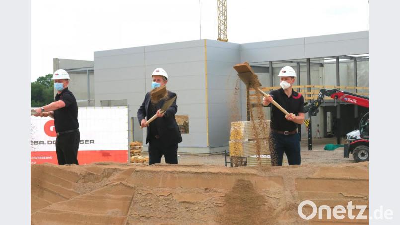 Während Unternehmer Ingo Maschek (Mitte) mit seinen Mitarbeitern und Ehrengästen zum Spatenstich ansetzte, waren die Bauarbeiten am neuen VW-Standort in Wackersdorf bereits in vollem Gange. Bild: Hirsch