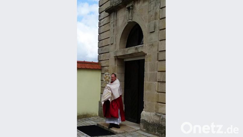 Alleine vor der Kirche segnete Pfarrer Heribert Stretz mit der Monstranz in alle Himmelsrichtungen die gesamte Pfarrei. Bild: hl