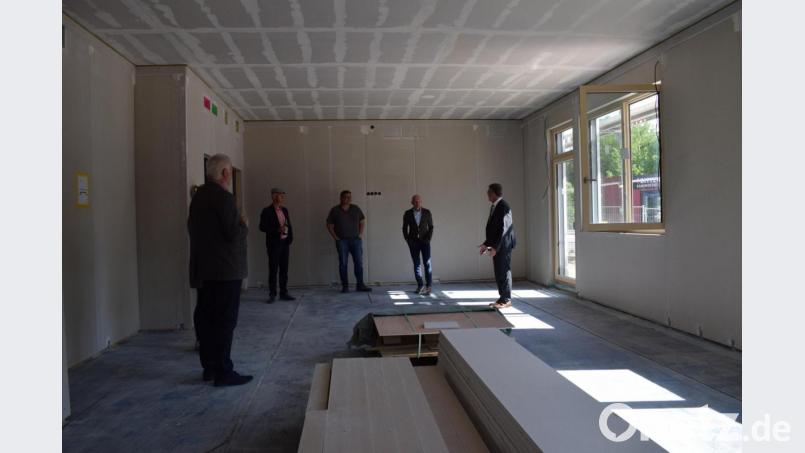 Bernd Büsching (zweiter von rechts) führt die Gäste beim Richtfest durch das Gebäude. In diesem Raum werden später Besprechungen stattfinden. Bild: szl