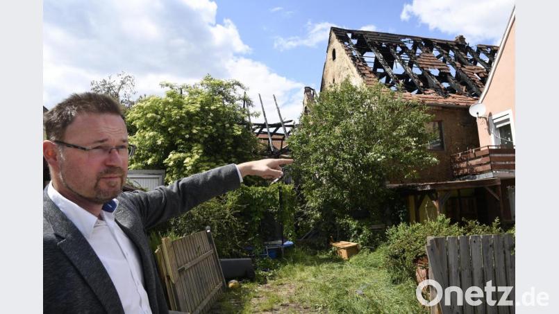 Hohenburgs Bürgermeister Florian Junkes erzählt im Hof hinter den abgebrannten Häusern am Marktplatz von seinen Eindrücken jener Nacht: Er war als Feuerwehrmann bei diesem Großbrand im Einsatz. Bild: Petra Hartl