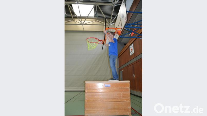 Stefan Merkl hat bereits den Grundrahmen am bestehenden Basketballkorb befestigt, in den er nun das Bambinibasket-Board samt Ring und Netz einhängt. Bild: puh