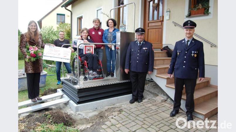 Christoph Koller nimmt den Scheck auf dem neuen Treppenlift persönlich in Empfang. Mit im Bild von links die Initiatorin der Engel-Aktion Sonja Muck, der Vorsitzender des Motorradstammtisches "Trentino" Stefan Braun, Christoph Kollers Eltern, .Michael Muck, Vorsitzender der Feuerwehr Teublitz und Stefan Niedermeier Vorsitzender der Feuerwehr Meßnerskreith. Bild: Muck/exb