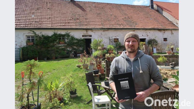 Josef Herrlein mit seinem Buch vor dem "alten Haus" in Letzau. Bild: Kunz
