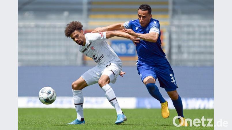 Luis Coordes (l) vom FC St. Pauli schirmt den Ball gegen Änis Ben-Hatira ab. Bild:  Matthias Hangst/Getty Images Europe/Pool/dpa