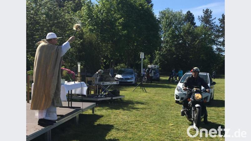 Vom Altarpodest aus besprengt Stadtpfarrer Johann Hofmann die an ihm vorbeifahrenden Fahrzeuge samt ihren Lenkern mit Weihwasser, so auch Stadtheimatpfleger Sepp Strobl auf seiner 600er-BMW, Baujahr 1975. Mit den Worten „Ja, öitza kenne’n erscht“ taucht der Pfarrer den Weihwasserpinsel tief ein und besprengte den Biker mit einer extra großen Portion. Bild: u