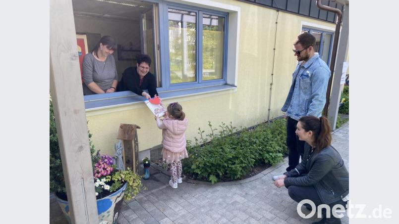 Über Fenster halten die Erzieherinnen Kontakt zu Eltern und Kindern der Tagesstätte. Bild: exb