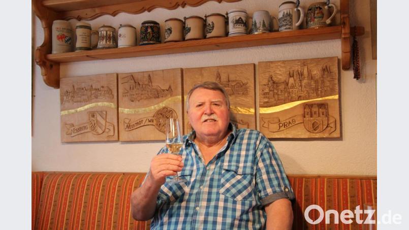 Auch wenn die große Geburtstagsfeier momentan wegen der Corona-Krise auf Eis liegt. An seinem 70. Geburtstag erhob der Schnitzer, Musiker und Familienmensch Alfons Kistenpfennig trotzdem sein Glas vor seinen geschnitzten Relieffs mit den Stadtwappen und Silhouetten von Prag, Tachau, Neustadt und Nürnberg. Bild: prh