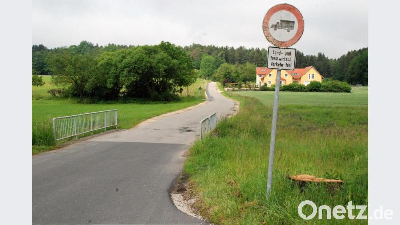 Der Freudenberger Gemeinderat gibt grünes Licht für die Sanierung der Straße, die die Ortschaft Greßmühle mit der Stadt Amberg (Bild hinter dem Anwesen rechts) verbindet. Dafür ist auch der Neubau einer Brücke (im Vordergrund) erforderlich. Bild: sche