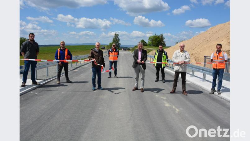 Am Donnerstagnachmittag durchschnitten Bürgermeister Lothar Müller (4. von rechts), Leitender Baudirektor Henner Wasmuth (2. von rechts), sowie die Baudirektoren Wolfgang Kederer (3. von links) und Stefan Noll (3. von rechts), im Beisein der am Bau beteiligten Handwerker, das rotweiße Trassenband und gaben so den Verkehr auf der Gemeindeverbindungsstraße Plößberg nach Schönkirch frei. Seit Freitagmittag darf hier wieder der Verkehr rollen. Da lacht sogar der weißblaue Himmel. Bild: jr