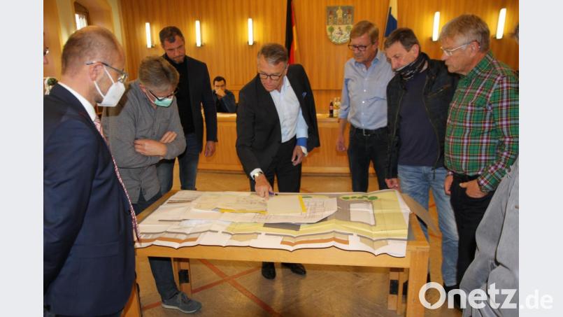 Bürgermeister Franz Stahl (Mitte) präsentierte die Baupläne für das Vereinslagerhaus auf einem Tisch inmitten des Rathaussaals, so dass die Bauausschussmitglieder ausreichend Gelegenheit hatten, die Pläne zu sichten. Bild: kro